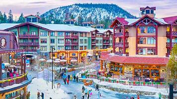 A snow-covered town with colorful buildings, including a hotel with multiple floors and balconies.