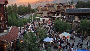 Una plaza al aire libre concurrida, con edificios al fondo y montañas a la distancia.