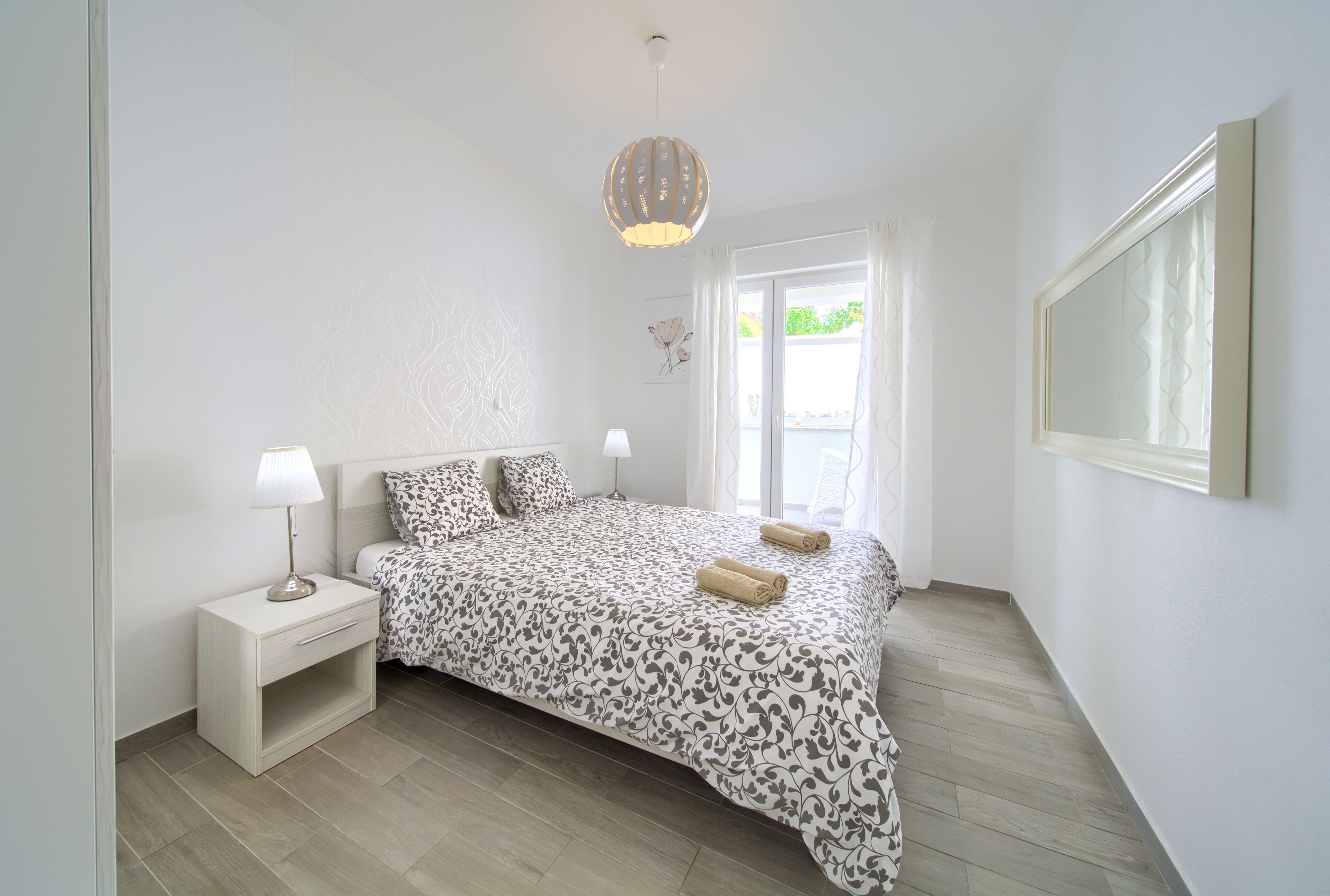 Une chambre à coucher avec un lit, une table de chevet, une lampe et un luminaire suspendu.