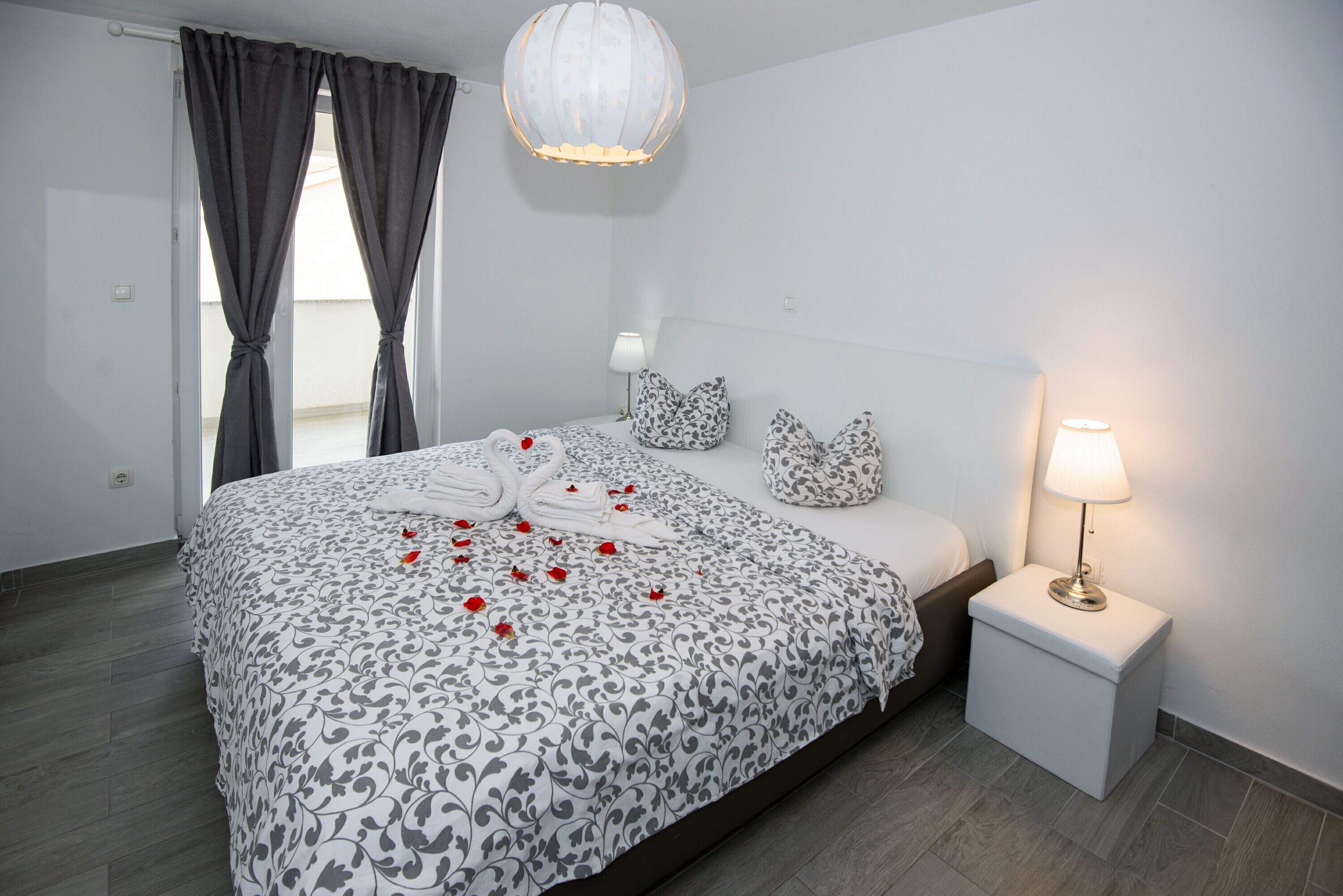 A neatly made bed with a patterned bedspread, a bedside lamp, and a small bedside table.