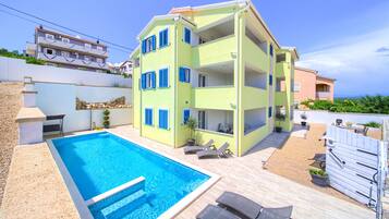 Enjoy a pool and lounge area surrounded by a deck and comfortable seating.