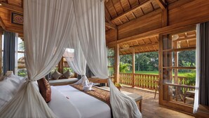A wooden cabin with a large bed, canopy, and a view of greenery outside. - The Kalyana Ubud Resort (Ubud)