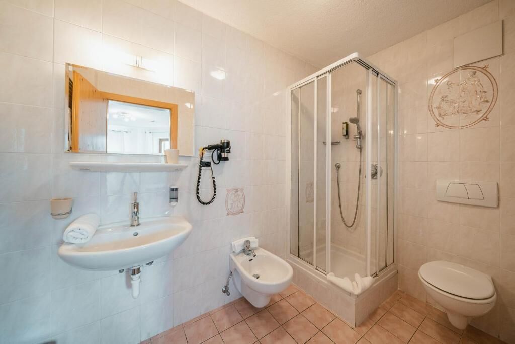 Une salle de bain équipée d’un lavabo, d’un bidet, de toilettes et d’une douche à parois de verre.