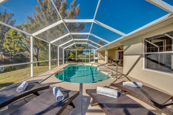 Relax in style with a pool surrounded by lounge chairs and a clear view of the surrounding landscape.