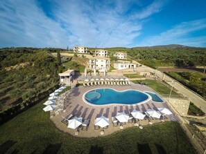 Ein Resort mit Schwimmbad, Außenbereich und Villen an einem Hügelhang.