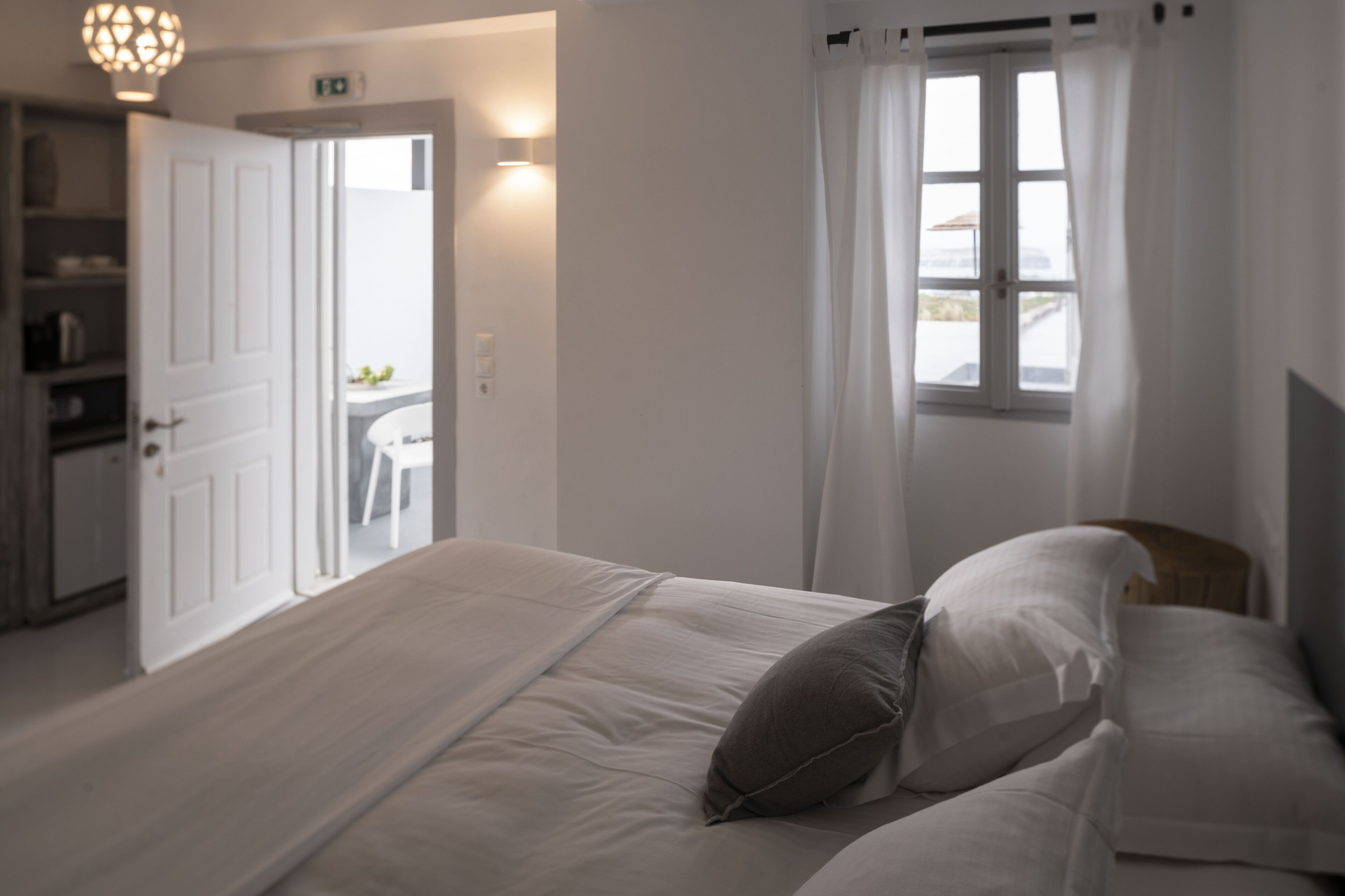 Ein Schlafzimmer mit einem großen Bett, einem Nachttisch, einem Kleiderschrank und einem Fenster mit Vorhängen.
