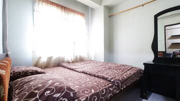 Une chambre à coucher avec un lit, une commode et un miroir.