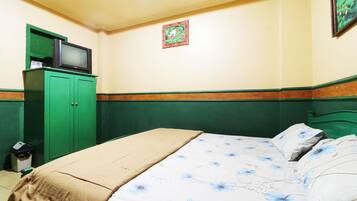 Ein Schlafzimmer mit einem Bett, einem grünen Kleiderschrank und einem Fernseher darauf.