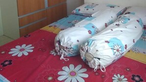 Un dormitorio con cama, armario y una estantería pequeña.