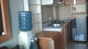 Una cocina compacta con dispensador de agua, un lavabo y un refrigerador.