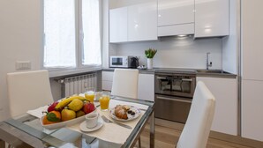 Eine moderne Küche mit weißen Schränken, einer Mikrowelle und einem Edelstahlbackofen.
