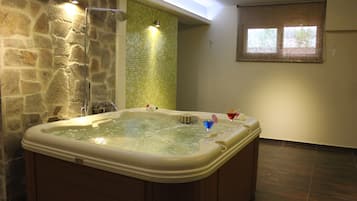 Bathroom features a hot tub and a window with blinds.
