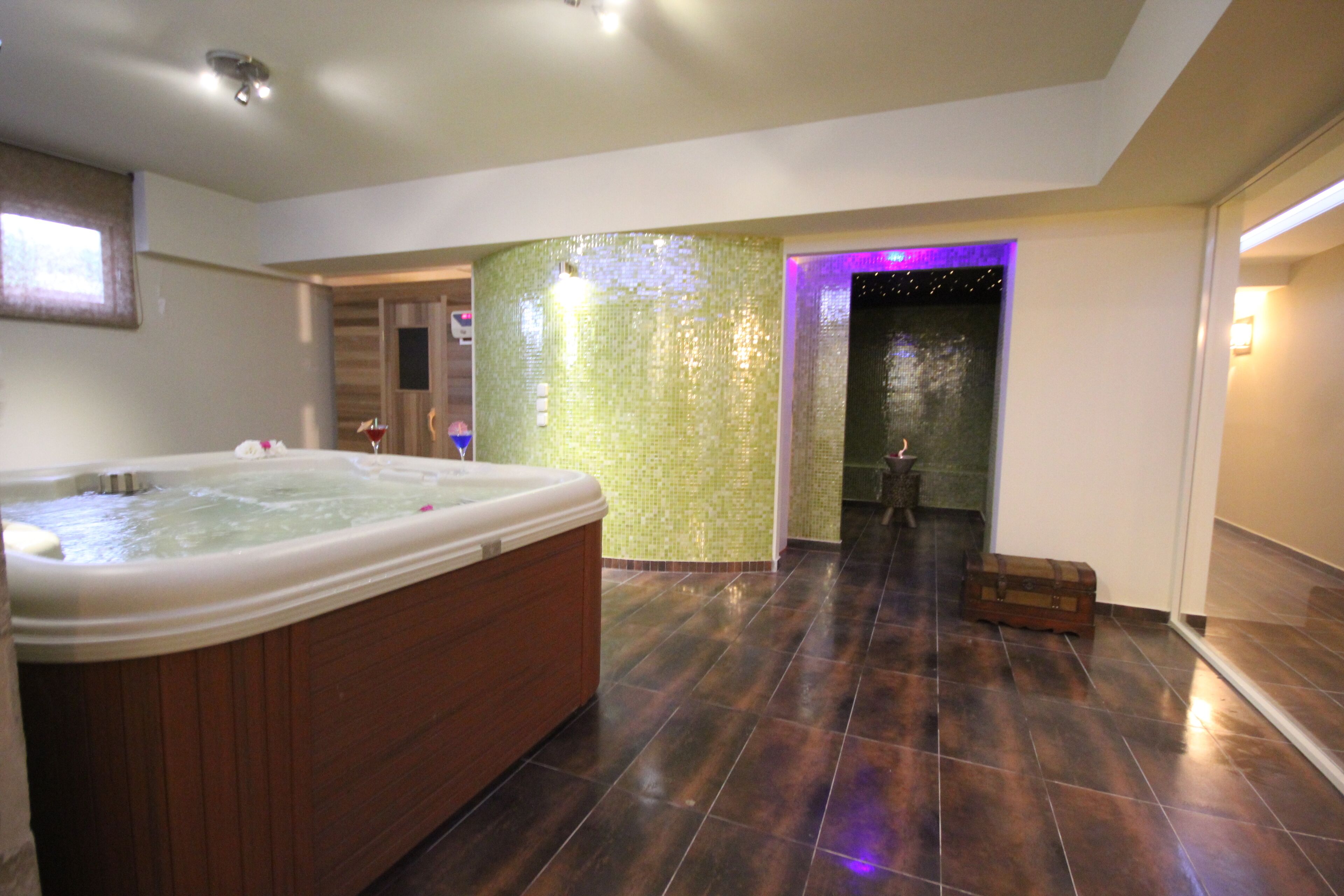 A spacious bathroom with a large bathtub, a shower area, and a tiled floor.
