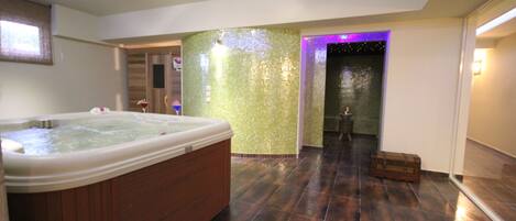 A spacious bathroom with a large bathtub, a shower area, and a tiled floor.