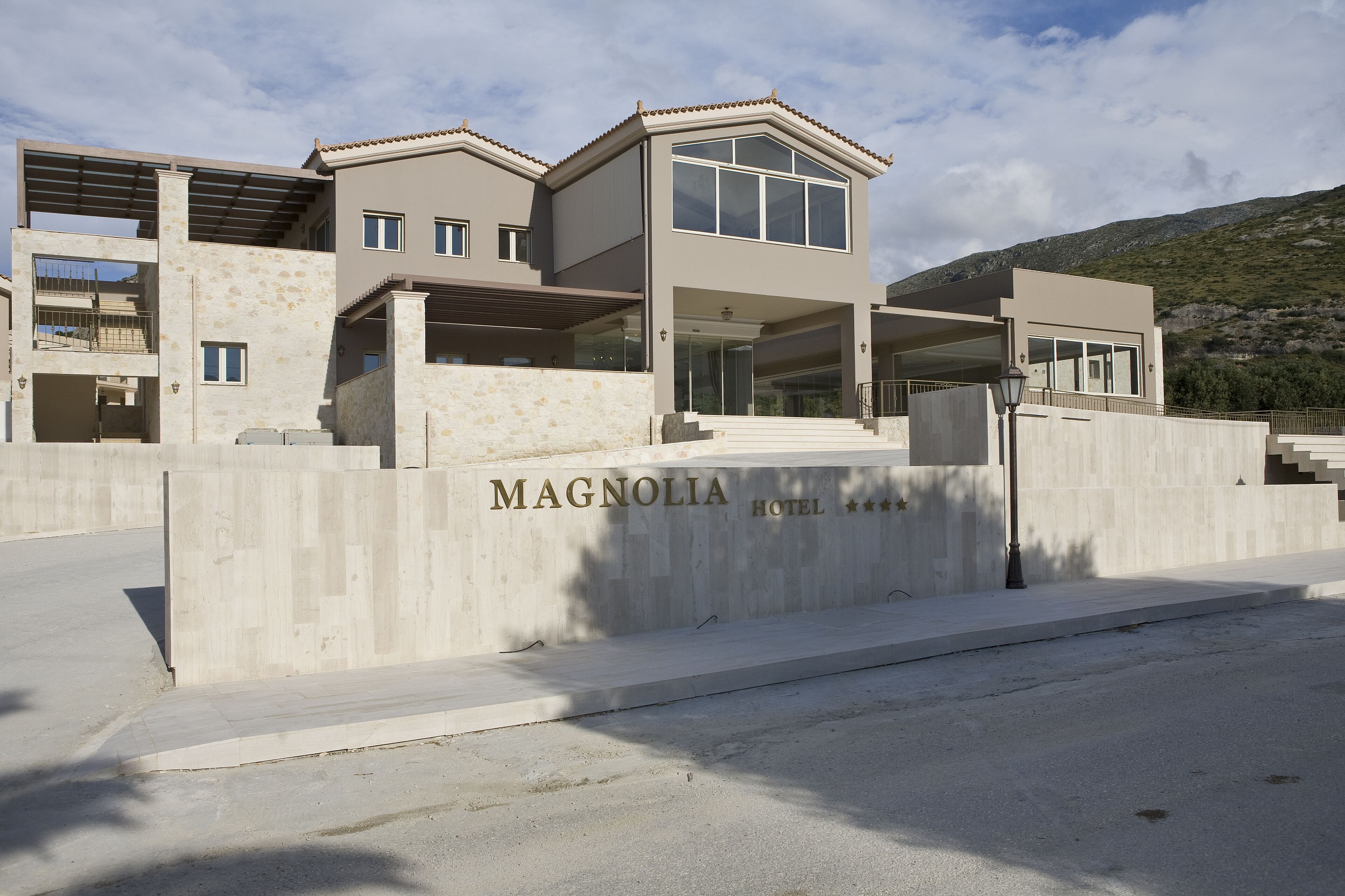 A modern hotel with a stone facade, large windows, and a prominent entrance.