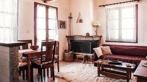 A cozy living room with a fireplace, wooden furniture, and a sofa. - Traditional Charming Stone Chalet (Distomo-Arachova-Antikyra)
