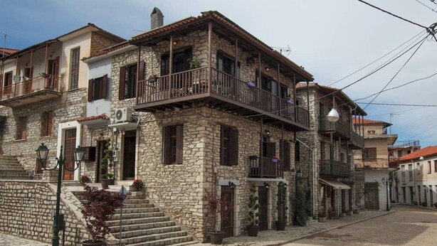 A stone building with a balcony, a staircase, and potted plants. - Antique Luxury Groundfloor Suite (Kalavrita)