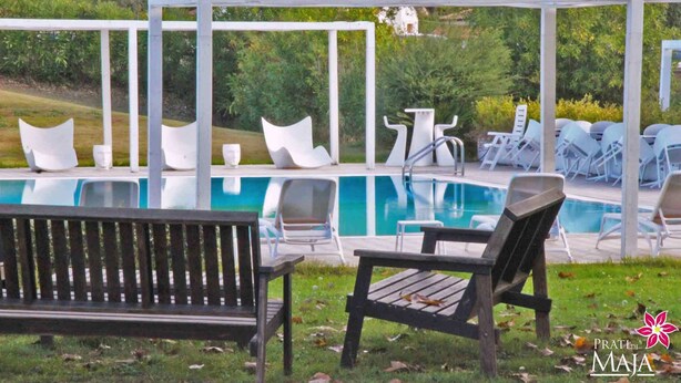 A pool area with lounge chairs and a wooden bench. - 30 sqm studio apartment - Kitchenette with living area, sleeping area, bathroom  (Miglianico)