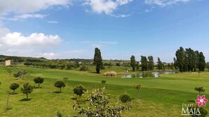 A golf course with a pond, trees, and a clear sky. - 30 sqm studio apartment - Kitchenette with living area, sleeping area, bathroom  (Miglianico)