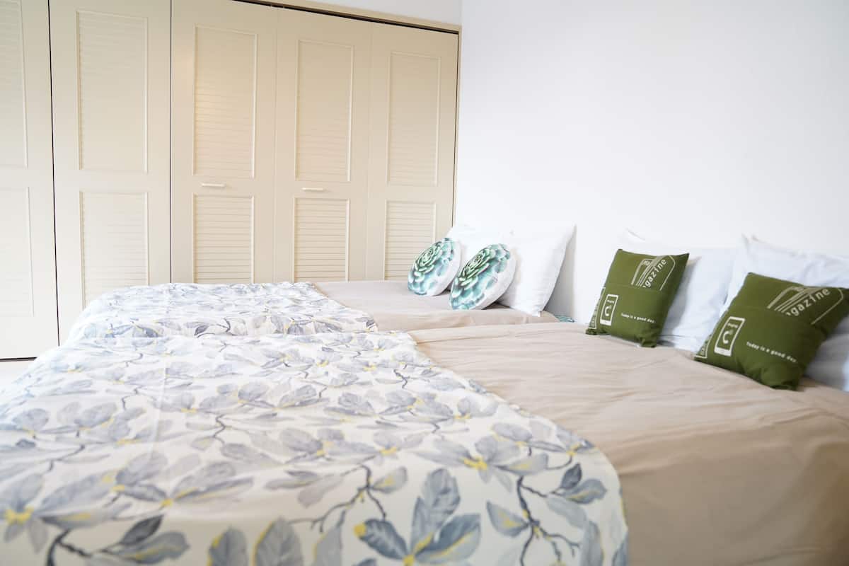 Un dormitorio con cama, armario y ventana.