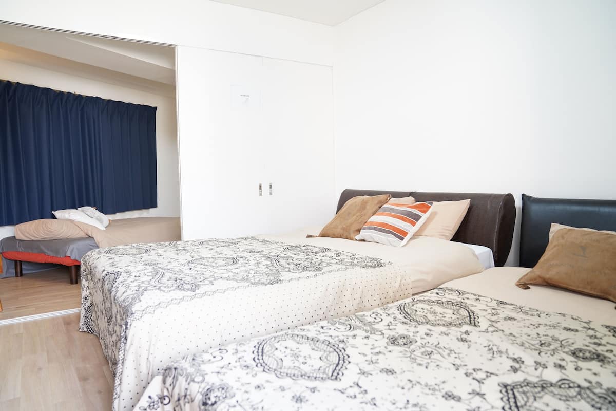 Un dormitorio con dos camas, un sofá y un armario.