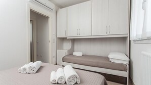 Habitación de hotel con cama, un escritorio pequeño y un armario.
