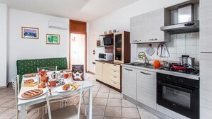 Una cocina moderna con comedor, que incluye un microondas, estufa y armarios.
