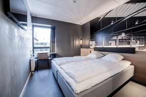 Une chambre d’hôtel moderne avec un grand lit, un bureau et une vue sur la ville.