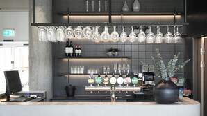 Zona de bar amb barra, diverses aixetes de cervesa i una varietat de recipients de vidre a les prestatgeries.