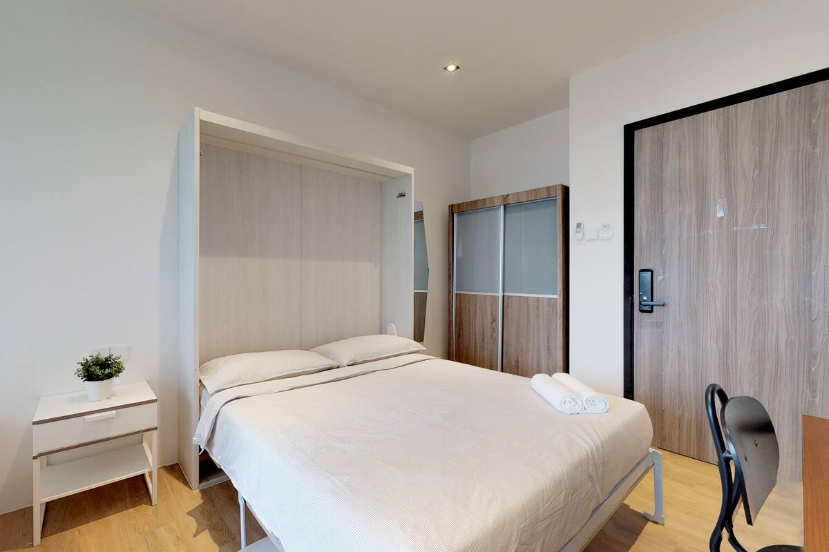Una camera da letto moderna con un letto, comodini, un armadio e una scrivania.