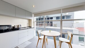 Una cocina moderna con comedor, ventanas amplias y vistas a la ciudad.