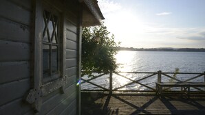 Una cabaña de madera con vista a un lago.