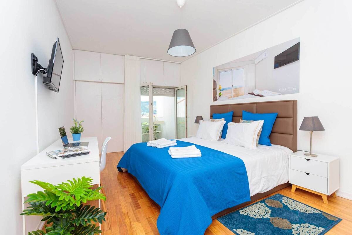 Ein modernes Schlafzimmer mit Bett, Nachttischen, Schreibtisch und Stuhl.