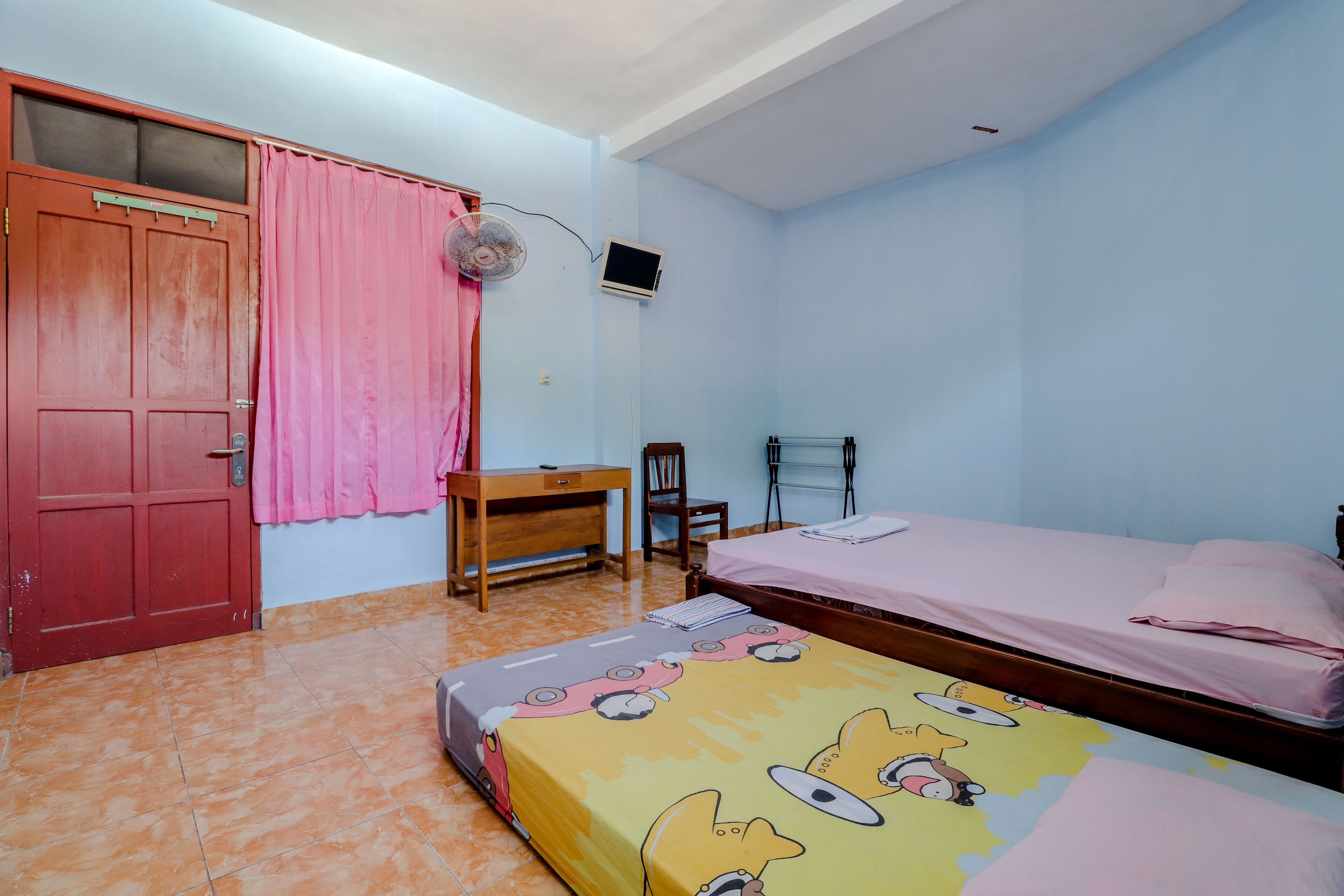 A bedroom with a bed, a desk, a chair, and a wardrobe.