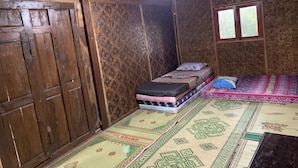 Una habitación rústica con paredes de madera y una cama individual con colcha estampada.