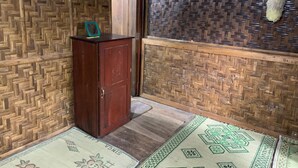 Una habitación con un aparador de madera, un muro tejido y un tapete estampado en el suelo.