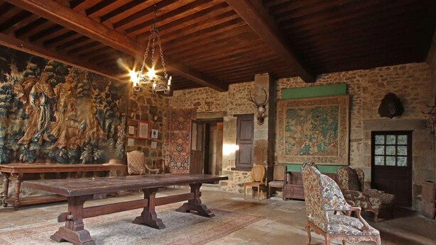 A rustic room with a wooden bench, patterned chairs, a stone wall, and a large tapestry. - Chaplain's House: Charm in Swiss Normandy, Pets Allowed (Rabodanges)