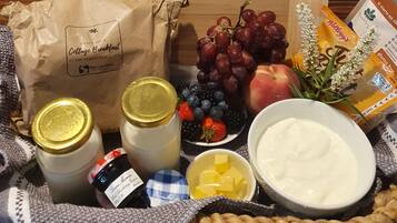 A breakfast spread with fruits, yogurt, honey, and a bag from Cottage Breakfast.