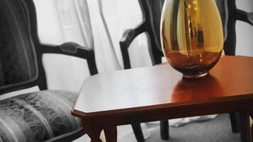 Una habitación con una mesa de madera, un jarrón y una revista.