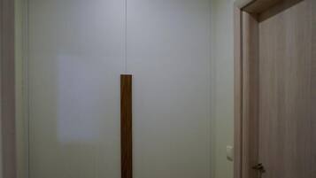 Una habitación con un armario grande, una puerta de madera y una lámpara en el techo.