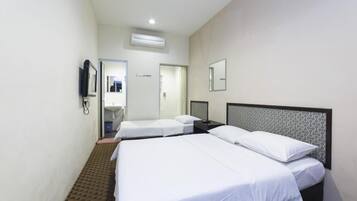 A hotel room with two single beds, a bedside table, a mirror, and a wall-mounted phone.
