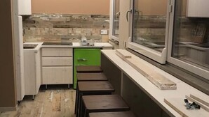 A compact kitchen with a window, a green cabinet, and a countertop. - SUITE LA GINESTRA among historic olive trees (Eboli SALERNO)