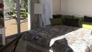 A bedroom with a bed, a wardrobe, a window, and a door. - SUITE LA GINESTRA among historic olive trees (Eboli SALERNO)