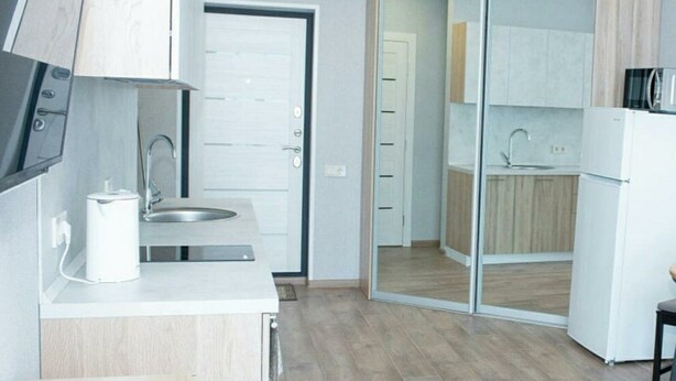 A modern kitchen with a built-in oven, a sink, and a microwave.