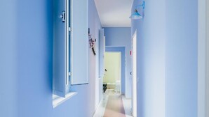 A hallway with blue walls and a light-colored floor.