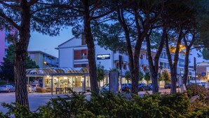A hotel with a modern design, featuring a glass facade and a well-lit entrance. - Miga Hotel Grado Centro (Grado)