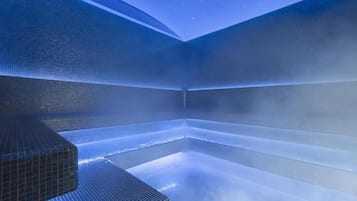 A modern spa with a geometric tiled design and a visible steam feature.