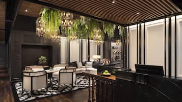 A modern living room with a sofa, chairs, a coffee table, and a dining area with a bench.
