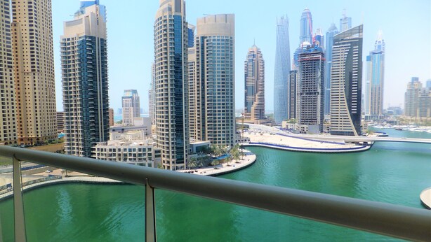 A view of a cityscape with tall buildings and a marina.