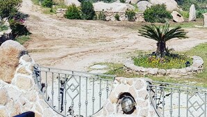 A stone pathway leading to a scenic overlook with a view of the sea and distant land. - COSTA SMERALDA APARTMENT in semi-detached villa with sea view in Cannigione alta (ARZACHENA)
